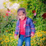 1 year poser baby toddler photography, garden, props, boy in check shirt, red tshirt, denim, ponytail, posing, anubhavshaphotography