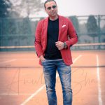 fashion photography nearby, outdoor, stadium, Delhi, man wearing red casual jacket, denim with black t-shirt, rayban sunglasses, anubhavshaphotography