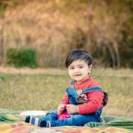 1 year poser baby photography, garden, props, girl in red sweat shirt and denim, sitting, anubhavshaphotography