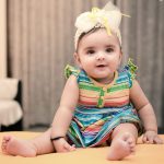 1 year sitter baby girl photoshoot at home wearing colorful strip dress tiara smiling