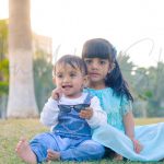 sibling photoshoot, 1 year bother and 6 years sister sitting in leisure valley park, gurugram, anubhavshaphotography