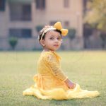 1 year sitting baby photoshoot outdoor garden yellow frill dress with tiara hair band