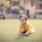 1 year sitting baby photoshoot outdoor garden yellow frill dress crawling toddler