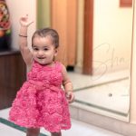 1 year poser baby photography, home, props, girl in floral red frill frock, raising hand, posing, anubhavshaphotography