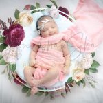 newborn infant photography, indoor home, props, anubhavshaphotography, pink wrapper, sleeping smiling girl in basket, flowers