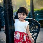 2 years poser baby photography, garden, props, girl in red white floral dress, posing with pillar, anubhavshaphotography