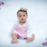 1 year baby photoshoot indoor home wearing crown pink white dress princess theme flowers