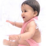 1 year sitting baby photoshoot indoor home wings and pink wrapper playing and laughing kid
