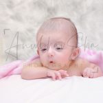 newborn infant photography, indoor home, props, anubhavshaphotography, pink wrapper, baby raising head, posing