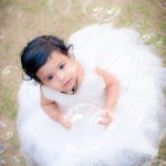 1 year baby photoshoot outdoor park wearing white frill frock bubbles