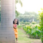5 years poser baby photography, garden, props, girl yellow dress, hiding behind tree, laughing, anubhavshaphotography