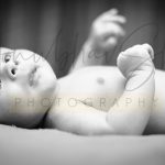 newborn baby photoshoot indoor home lying in diaper and smiling