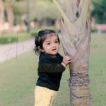 10 months poser baby photography, garden, props, boy in black tshirt, yellow pant, standing with plant, anubhavshaphotography