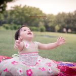 1 year sitter baby girl photoshoot outdoor park enjoying and playing hands looking up