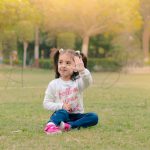 2 years poser baby photography, garden, props, girl white tshirt, jeans, 2 ponytails, showing hand, anubhavshaphotography