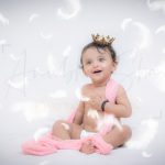 1 year baby photoshoot indoor home crown prince theme white feathers