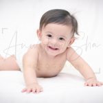 1 year poser baby photography, home, props, boy in diaper, lying on bed, smiling, anubhavshaphotography