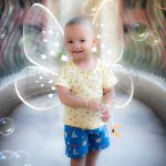 2 years poser baby photography, home, props, girl with wings in yellow top, bubbles. fairy theme, anubhavshaphotography