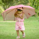 1 year poser baby photography, outdoor, garden, props, pink heart dress, rain, holding pink ubrella, anubhavshaphotography