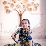 4 years girl photoshoot indoor home, sitting floor, posing blue yellow floral dress, tree background