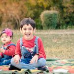 sibling photography, outdoor garden, Faridabad, 1 year girl, 6 years boy, red tshirt, denim jeans, posing, smiling, anubhavshaphotography