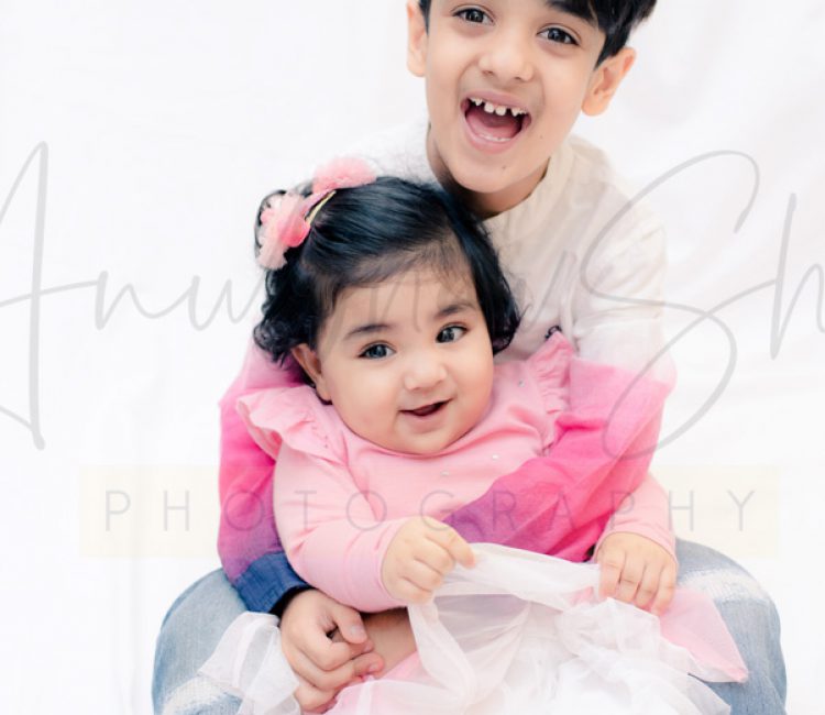 sibling photoshoot indoor, gurugram, 1 year girl, 6 years boy, laughing pose, pink white dresses, anubhavshaphotography