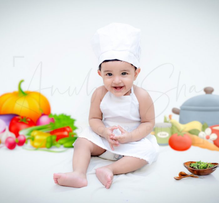 1 year sitting baby photoshoot indoor home chef theme with vegetables and fruits