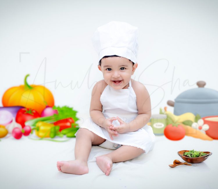 1 year sitting baby photoshoot indoor home chef theme with vegetables and fruits