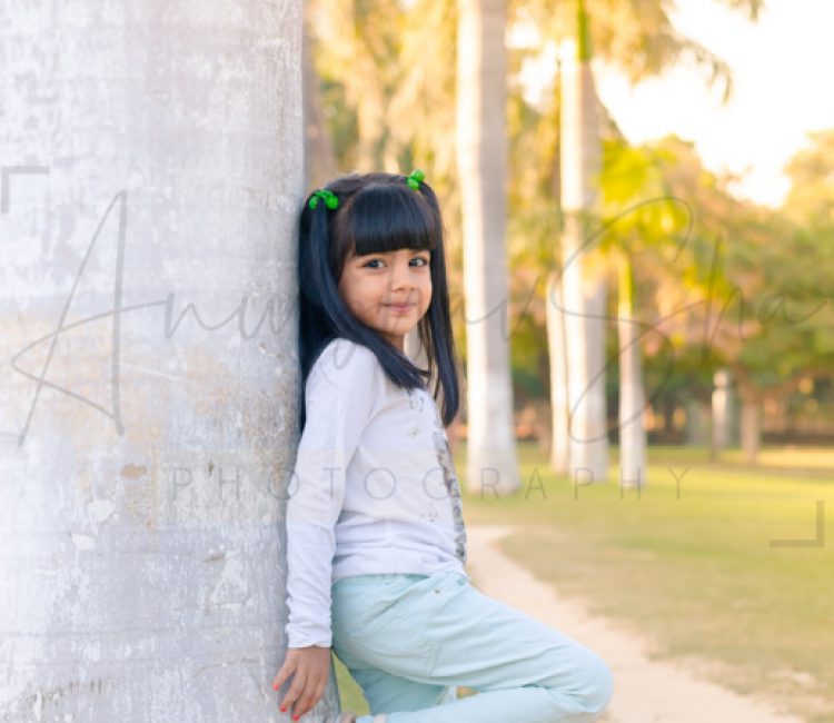 6 years poser baby photography, garden, props, girl in white tshirt, pants, 2 ponytails, with tree, anubhavshaphotography