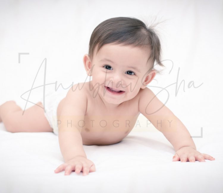 1 year poser baby photography, home, props, boy in diaper, lying on bed, smiling, anubhavshaphotography